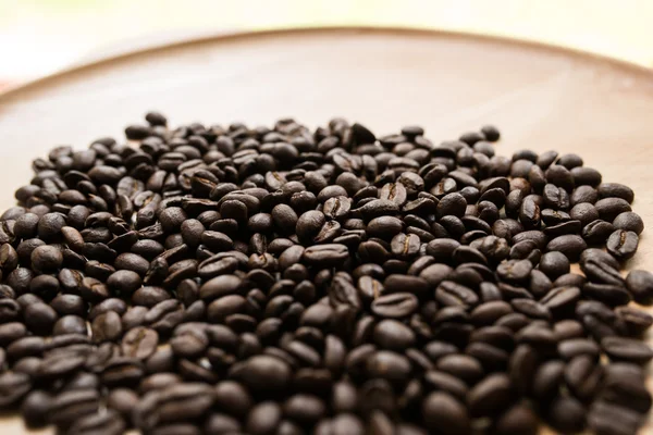 kavrulmuş kahve çekirdeği üzerinde ahşap tabak