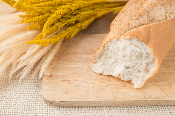 Baguettes de pan francés sobre tabla de pan en textura de arpillera — Foto de Stock