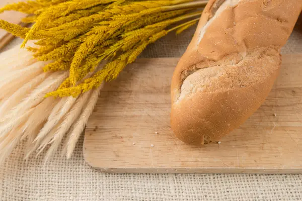 Baguette di pane francese su tavola da pane su texture di iuta — Foto Stock