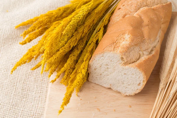 Rebanadas afiladas de baguettes de pan francés en el tablero del pan — Foto de Stock