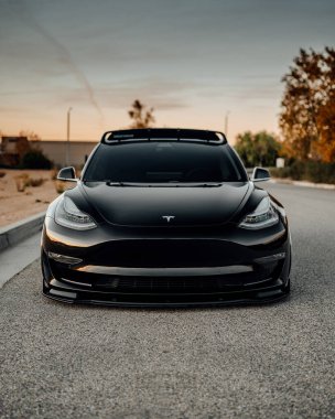 LA, California; December 6, 2020. Black Tesla Model 3 at the parking lot close to the building. Editorial photo.