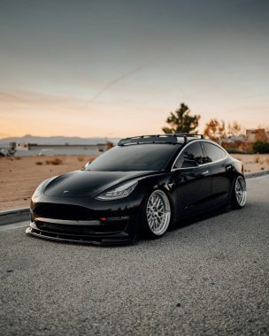 LA, California; December 6, 2020. Black Tesla Model 3 at the parking lot close to the building. Editorial photo.