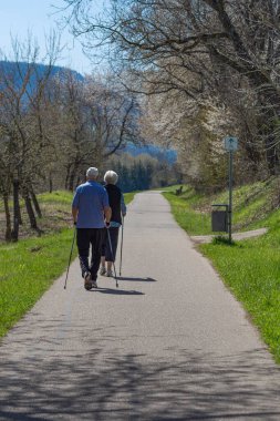 Kuzey Almanya kırsalında bahar aylarında yürüyen yaşlı bir çift.