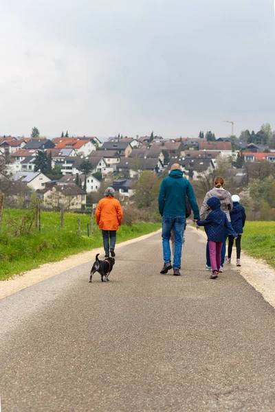 family on outdoor walk on german countryside with dog pug and children and parents