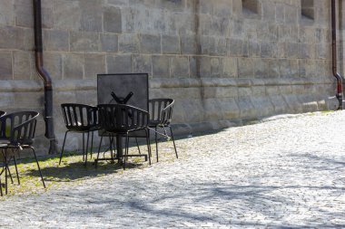 Cavid-19 'daki kafe restoranı Almanya' nın tarihi şehrinde boş masa ve sandalyeleri kilitleyin.