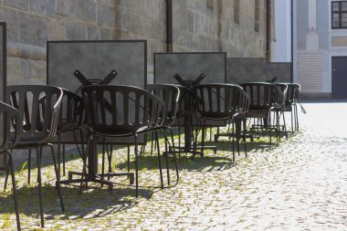 Cavid-19 'daki kafe restoranı Almanya' nın tarihi şehrinde boş masa ve sandalyeleri kilitleyin.