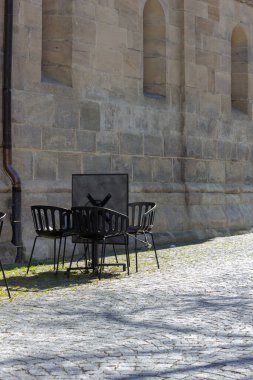 Cavid-19 'daki kafe restoranı Almanya' nın tarihi şehrinde boş masa ve sandalyeleri kilitleyin.