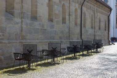 Cavid-19 'daki kafe restoranı Almanya' nın tarihi şehrinde boş masa ve sandalyeleri kilitleyin.