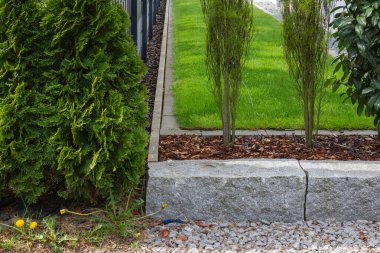 Almanya 'da baharda yeşil ve taş duvar cepheleri olan modern bahçe evleri.