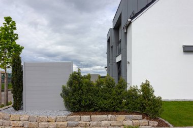 Almanya 'da baharda yeşil ve taş duvar cepheleri olan modern bahçe evleri.