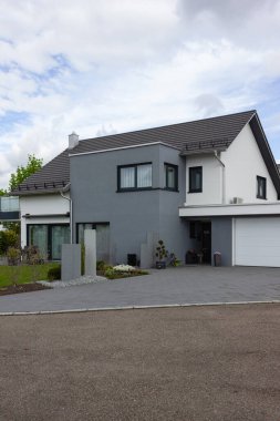 Almanya 'nın bahar kırsalında beyaz ve gri renkli modern ev cephesi