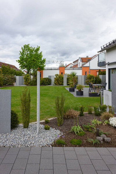 modern garden area of houses at spring in germany with fresh plants green and stone wall facades