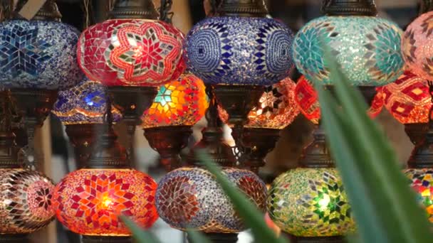 Bunte türkische Lampen aus Glasmosaik leuchten. Arabische mehrfarbige authentische Lichter im Retro-Stil. Viele beleuchtete marokkanische Bastellaternen. Orientalisch-islamisches Dekor im Nahen Osten. Glänzender Folklore-Laden — Stockvideo