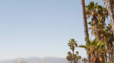Kaliforniya plaj estetiği, klasik dönme dolap, Santa Monica Pasifik Okyanusu 'ndaki iskeledeki eğlence parkı. Yaz ikonik manzarası, palmiye ağaçları ve gökyüzü, kopya alanı ile Los Angeles 'ın sembolü, CA USA