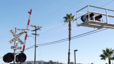 Amerika 'da seviye çapraz uyarı sinyali. Kaliforniya 'da demiryolu kavşağında çapraz ateş uyarısı ve kırmızı trafik ışığı. Demiryolu ulaşım güvenlik sembolü. Tehlike ve tren raylarıyla ilgili uyarı işareti