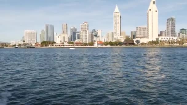 Metropolis stedelijke skyline, hoogbouw wolkenkrabbers van de stad centrum, San Diego Bay, Californië Verenigde Staten. Gebouwen aan het water in de buurt van Stille Oceaan haven. Uitzicht vanaf boot, nautisch openbaar vervoer naar Coronado — Stockvideo