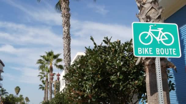 Moto Rota sinal de estrada verde na Califórnia, EUA. Bicicleta faixa singpost. Bikeway em Oceanside estância turística pacífica. Placa de ciclismo e palma. Estilo de vida saudável, recreação e segurança símbolo de ciclismo — Vídeo de Stock