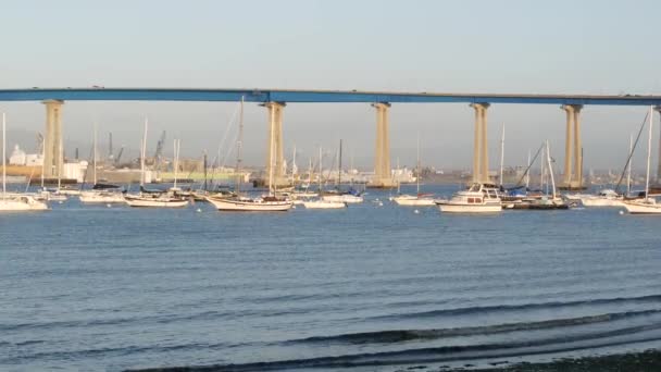 Famoso puente de automóvil Coronado en el condado de San Diego, California, EE.UU. Yates de lujo anclados en la bahía del Océano Pacífico, puerto en la ciudad americana. Infraestructura de transporte para automóviles sobre el mar — Vídeo de stock
