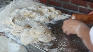 Meksika tortillaları için hamuru un tozuyla yoğuran kadın. Latin Amerika mısır ekmeği hazırlayan bir kadın. Taco, nacho ve burrito için mısır ekmeği pişirme işlemi