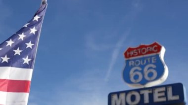 Tarihi güzergah 66 'daki motelin retro tabelası Amerika' nın klasik yol gezisi sembolü. Arizona çölünde ikonik pano. Eski moda neon tabela. Ulusal bayrak dalgalanması