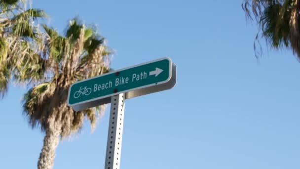 Ruta en bicicleta verde señal de tráfico en California, Estados Unidos. Bicicleta carril singpost. Bicicleta en Oceanside complejo turístico pacífico. Letrero de carril bici y palma. Estilo de vida saludable, recreación y seguridad símbolo de ciclismo — Vídeos de Stock