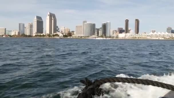 Metropolis stedelijke skyline, hoogbouw wolkenkrabbers van de stad centrum, San Diego Bay, Californië Verenigde Staten. Gebouwen aan het water in de buurt van Stille Oceaan haven. Uitzicht vanaf boot, nautisch openbaar vervoer naar Coronado — Stockvideo