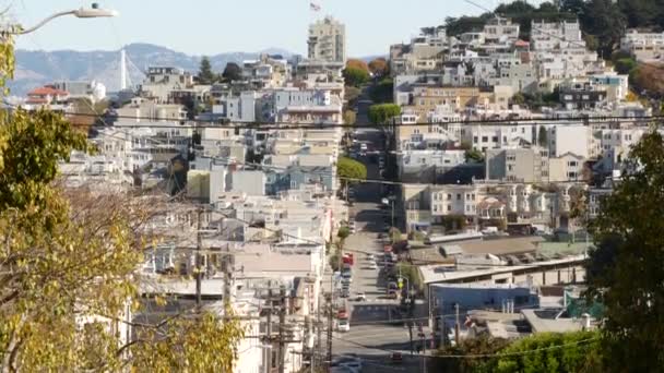 Ikonisk kuperad gata och vägskäl i San Francisco, norra Kalifornien, USA. Brant nedförsbacke och gångväg. Downtown fastigheter, segrande radhus med andra bostadshus — Stockvideo