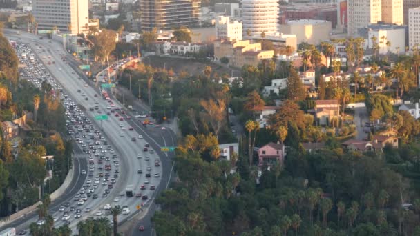 Drukke spitsuur intercity snelweg in Metropolis, Los Angeles, Californië, USA. Stedelijke file op de weg in het zonlicht. Luchtfoto van auto 's op meerbaans oprit. Snelweg met auto 's in Los Angeles — Stockvideo