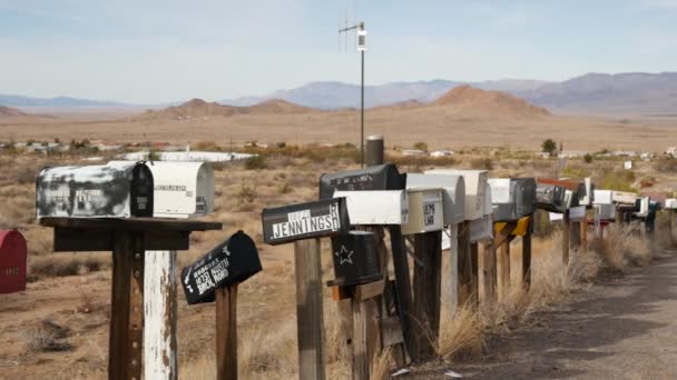 道路交差点のヴィンテージドロップボックスの行は、乾燥アリゾナ砂漠、米国。観光ルート66の道端に郵便物レトロメールボックス。柱の上に昔懐かしい金属製のグランジポストボックスの住所 — ストック動画