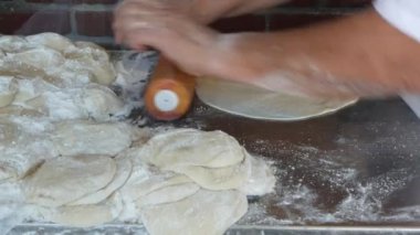 Meksika tortillaları için hamuru un tozuyla yoğuran kadın. Latin Amerika mısır ekmeği hazırlayan bir kadın. Taco, nacho ve burrito için mısır ekmeği pişirme işlemi