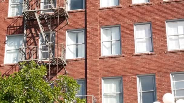 Fire escape ladder outside residential brick building in San Diego city, USA. Typical New York style emergency exit for safe evacuation. Classic retro house exterior as symbol of real estate property — Stock Video
