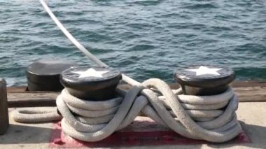 Metalik kazığa bağlanmış halatla yıldızlar, San Diego, California 'nın yelkenli limanı. Denizci gemisi rıhtıma demir attı. Rıhtımda kablo bağı kuruldu. Denizcilik ve donanma filosunun sembolü, ABD bayrağı.