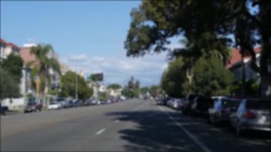 Los Angeles, Kaliforniya 'nın şehir merkezindeki caddelerde araba sürüyorum. Garaj yolundaki arabanın ön camından odaklı olmayan görüntü. Hollywood 'da araçları olan bulanık bir yol. Kamera otomobilin içinde, LA şehri estetiği.