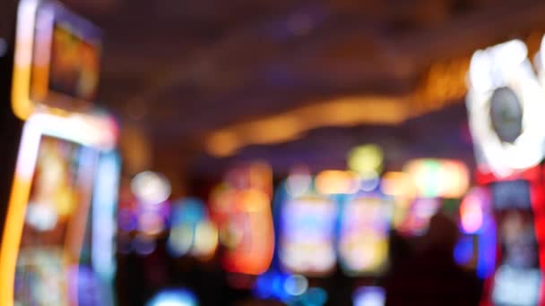 Defocused slot machines glow in casino on fabulous Las Vegas Strip, USA. Blurred gambling jackpot slots in hotel near Fremont street. Illuminated neon fruit machine for risk money playing and betting — Stock Video