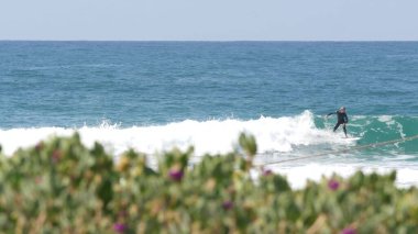 Encinitas, California USA - 23 Şubat 2020: Okyanusta sörfçüler, Pasifik kıyılarında büyük mavi deniz dalgaları. İnsanlar sörf yapıyor, sörf tahtalarıyla spor yapıyor. Sağlıklı yaşam tarzı, su sporları hobisi. Kişi ve sörf veya gelgit.