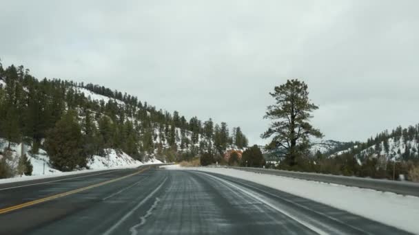 在美国从锡安到布莱斯峡谷的公路旅行，在犹他州驾驶汽车。搭便车在美国旅行，89号公路到迪克西森林。冬天的地方旅行,宁静的空气和雪山.从车上看 — 图库视频影像