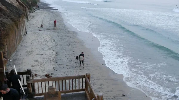 Les gens marchent sur la plage après le surf. Surfeurs près des vagues avec planche de surf. Encinitas, Californie États-Unis — Photo