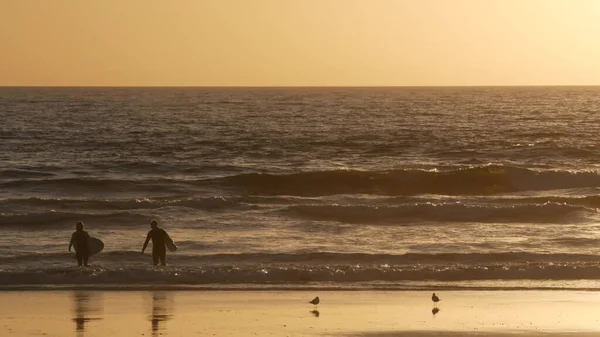 Szörfös sziluett, csendes-óceáni tengerparti naplemente. Az emberek szeretnek szörfözni. Oceanside, Kalifornia Egyesült Államok — Stock Fotó