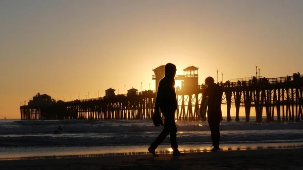 サーファーのシルエット、太平洋のビーチの夕日。人々はサーフィンを楽しむ。カリフォルニア州オーシャンサイド — ストック写真