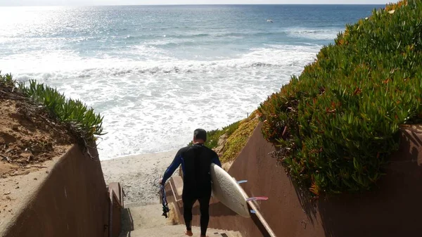 Surfistas en las escaleras. Hombre mujer practicando surf, escaleras costeras, acceso a la playa. Personas en California Estados Unidos —  Fotos de Stock