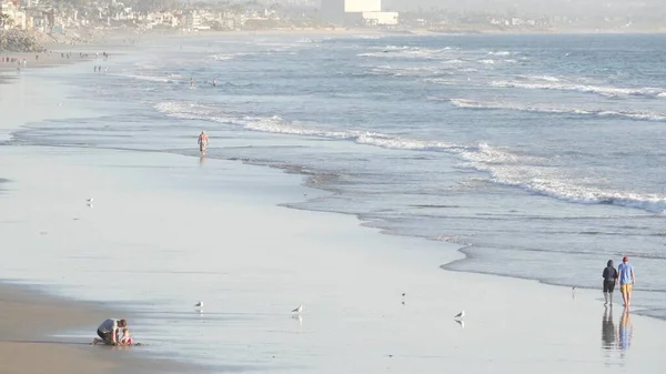 People walking strolling. Pacific ocean, sea water wave. Beachfront vacations resort. California USA — Stock Photo, Image
