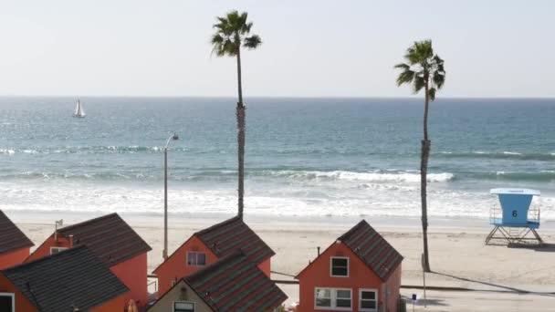 Oceanside California USA 'deki kulübeler. Deniz kenarındaki bungalovlar. Okyanus sahili palmiyeleri. Cankurtaran kulesi. — Stok video