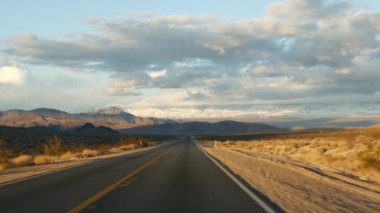 Ölüm Vadisi 'nden Las Vegas, Nevada' ya arabayla yolculuk. Amerika 'da otostop çekmek. Otoyol yolculuğu, dramatik atmosfer, günbatımı dağı ve Mojave çölleri. Arabadan görüntüle