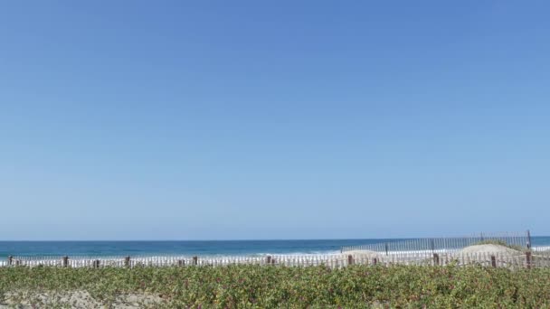 Velké přílivové vlny na pláži, Kalifornské pobřeží USA. Pobřeží Tichého oceánu, laťkový plot na pobřeží. — Stock video