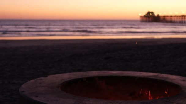 Pozzo del fuoco in California Stati Uniti. Fuoco del campo sulla spiaggia dell'oceano crepuscolare, fiamma del falò dalle onde dell'acqua di mare. — Video Stock