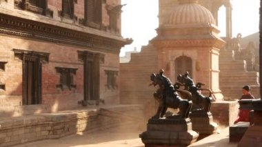 BHAKTAPUR, KATHMANDU, NEPAL - 18 Ekim 2018 Doğu antik kentinde deprem sonrası yaya trafiği. Ulusal giysili yerel newar insanları tapınağın yakınındaki sokaklara gidiyorlar..