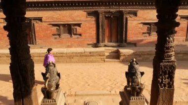 BHAKTAPUR, KATHMANDU, NEPAL - 18 Ekim 2018 Doğu antik kentinde deprem sonrası yaya trafiği. Ulusal giysili yerel newar insanları tapınağın yakınındaki sokaklara gidiyorlar..