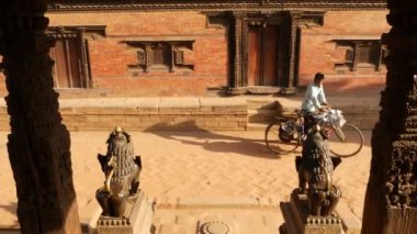 BHAKTAPUR, KATHMANDU, NEPAL - 18 Ekim 2018 Doğu antik kentinde deprem sonrası yaya trafiği. Ulusal giysili yerel newar insanları tapınağın yakınındaki sokaklara gidiyorlar..