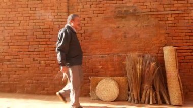 BHAKTAPUR, KATHMANDU, NEPAL - 18 Ekim 2018 Doğu antik kentinde deprem sonrası yaya trafiği. Ulusal giysili yerel newar insanları tapınağın yakınındaki sokaklara gidiyorlar..