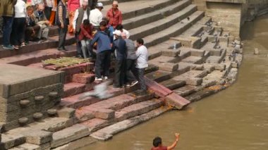 KATHMANDU, NEPAL - 8 Ekim 2018: Yerel Hindu halkı, Pashupatinath tapınağındaki kutsal Bagmati Nehri kıyısındaki yanan ghatlarda geleneksel yakma töreni.